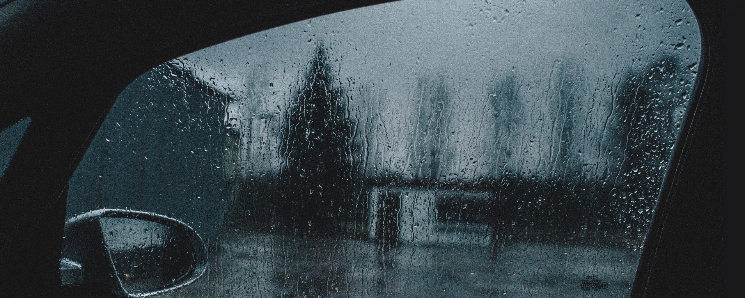Мокрое стекло автомобиля. Дождь на окне машины. Дождь на стекле машины. Сквозь мокрое стекло.