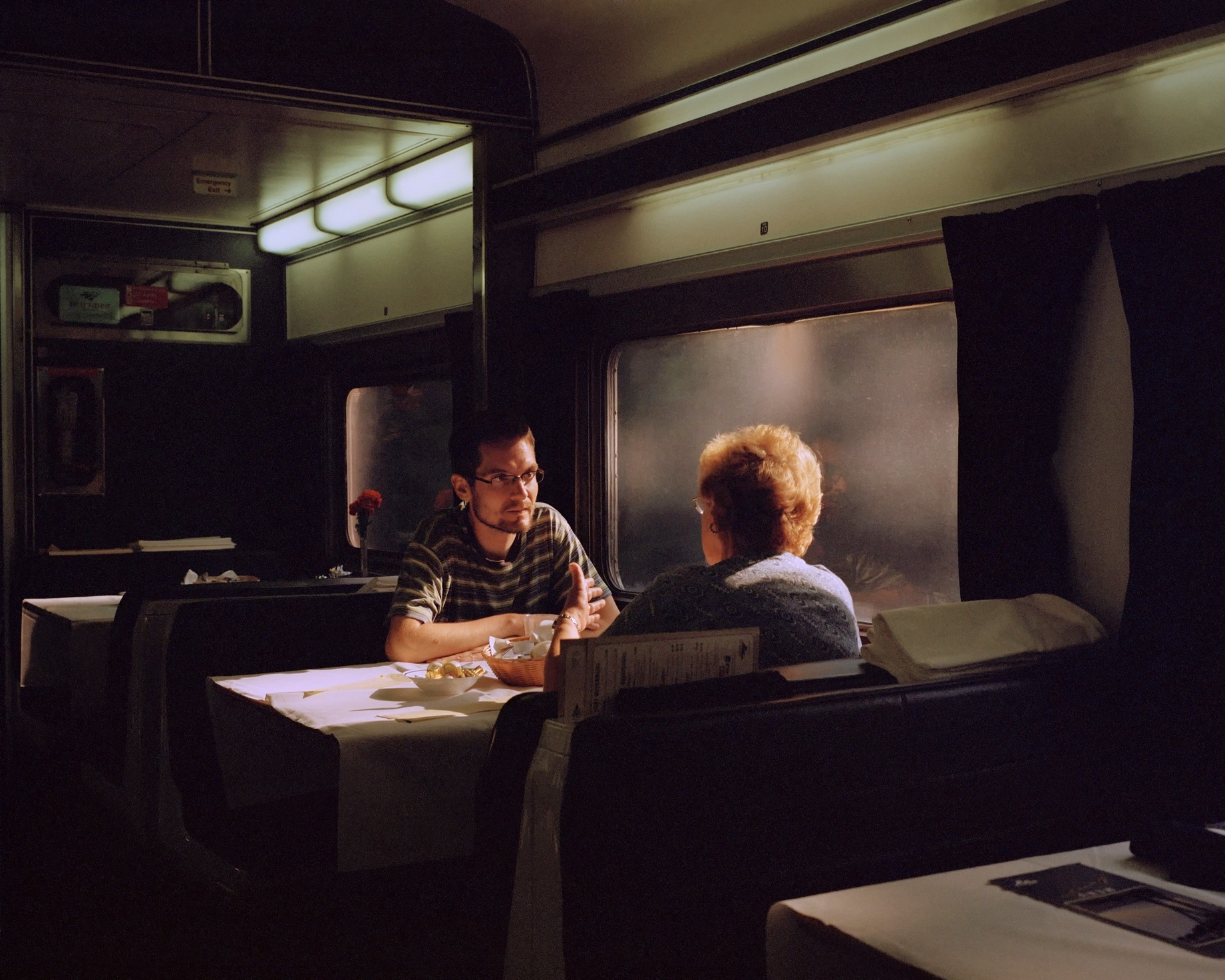 Ночью пассажиры утомленные долгим путешествием дремали. Купе поезда Амтрак. Люди в поезде. Пассажиры в поезде. Разговор в поезде.