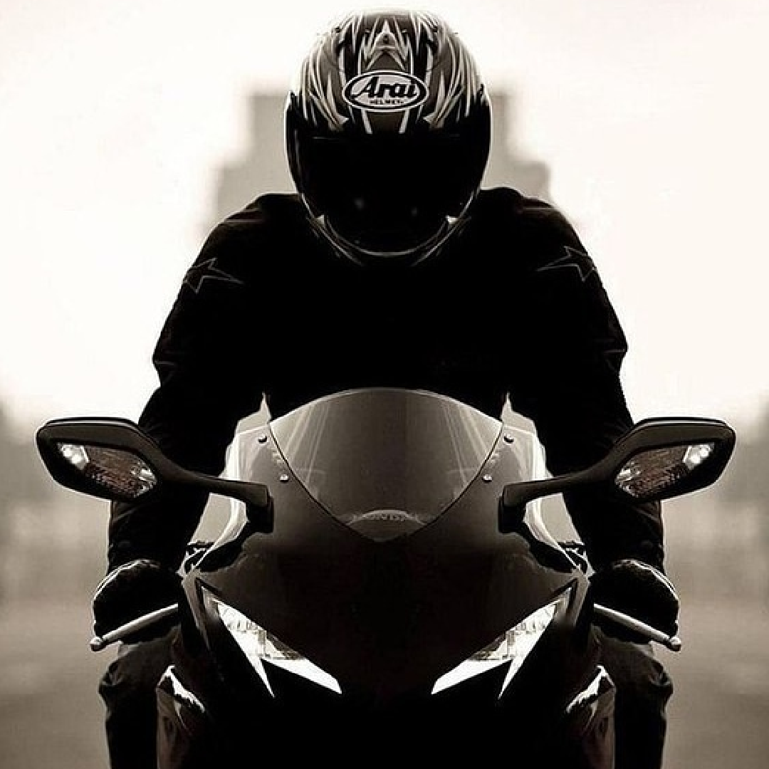 Мотоциклист одевает шлем рядом с мотоциклом — Авы и картинки