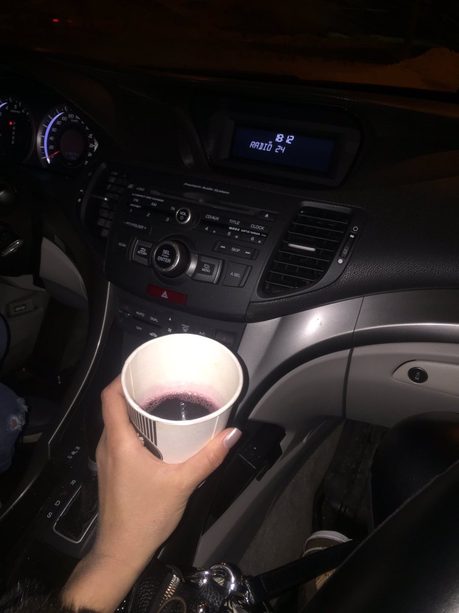 Женская рука с кофе в машине
