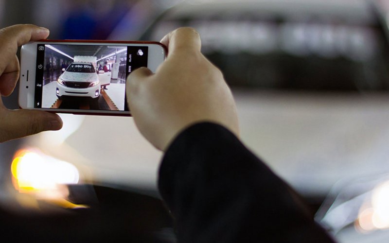 Фотографирует автомобиль