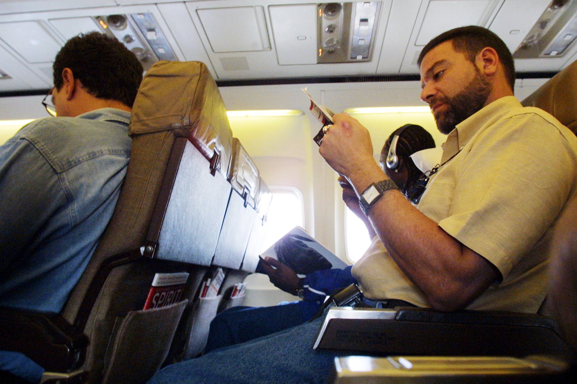 Люди сидят в самолете. Кресло "самолет". Сижу в самолете. Люди в самолете. Спинка кресла в самолете.